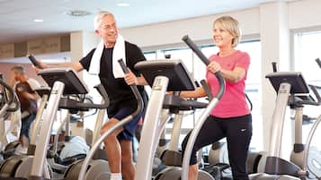 Una palestra con diverse tapis roulant e una persona che ne utilizza uno.