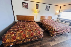 Two beds with wooden headboards, a bedside table, a lamp, and framed pictures on the wall. - Big South Fork Trail Lodge Stearns (Stearns)