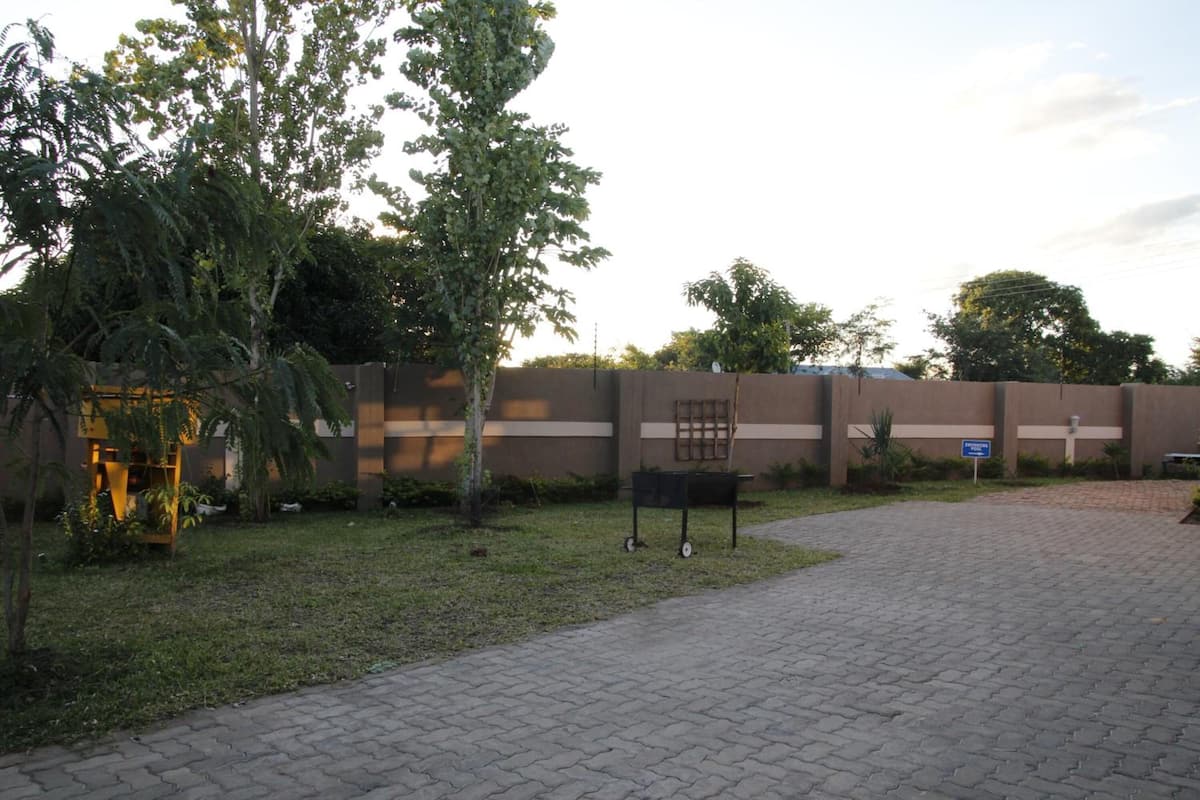 An outdoor area with a paved walkway, a bench, and a low wall with a sign.