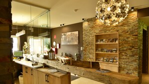 Una cocina moderna con encimera de madera, pared decorativa de ladrillo y lámpara colgante.