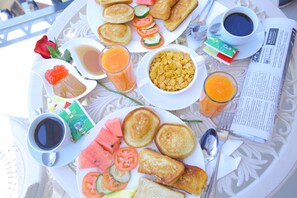 Una bandeja de desayuno con tostadas, fruta, cereal y café.