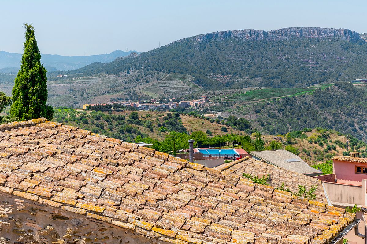 Tejas de terracota, una piscina y vistas a campos y colinas en terrazas.