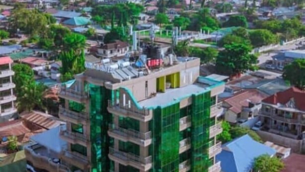 A multi-story building with a modern design, featuring balconies and a green facade. - Rungwe Hotel (Dar es Salaam)