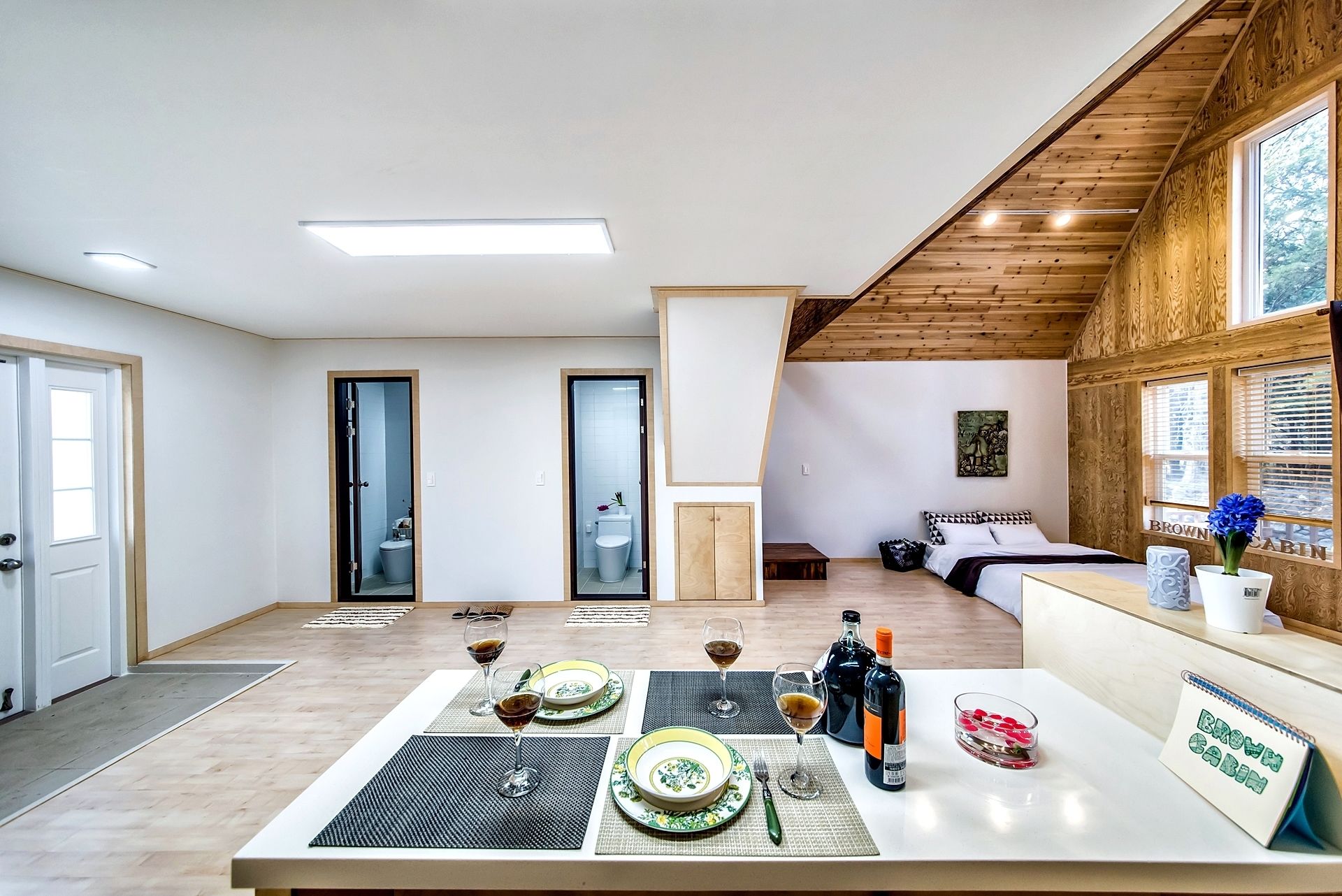 A modern interior with a dining area, a bed, and a bathroom.