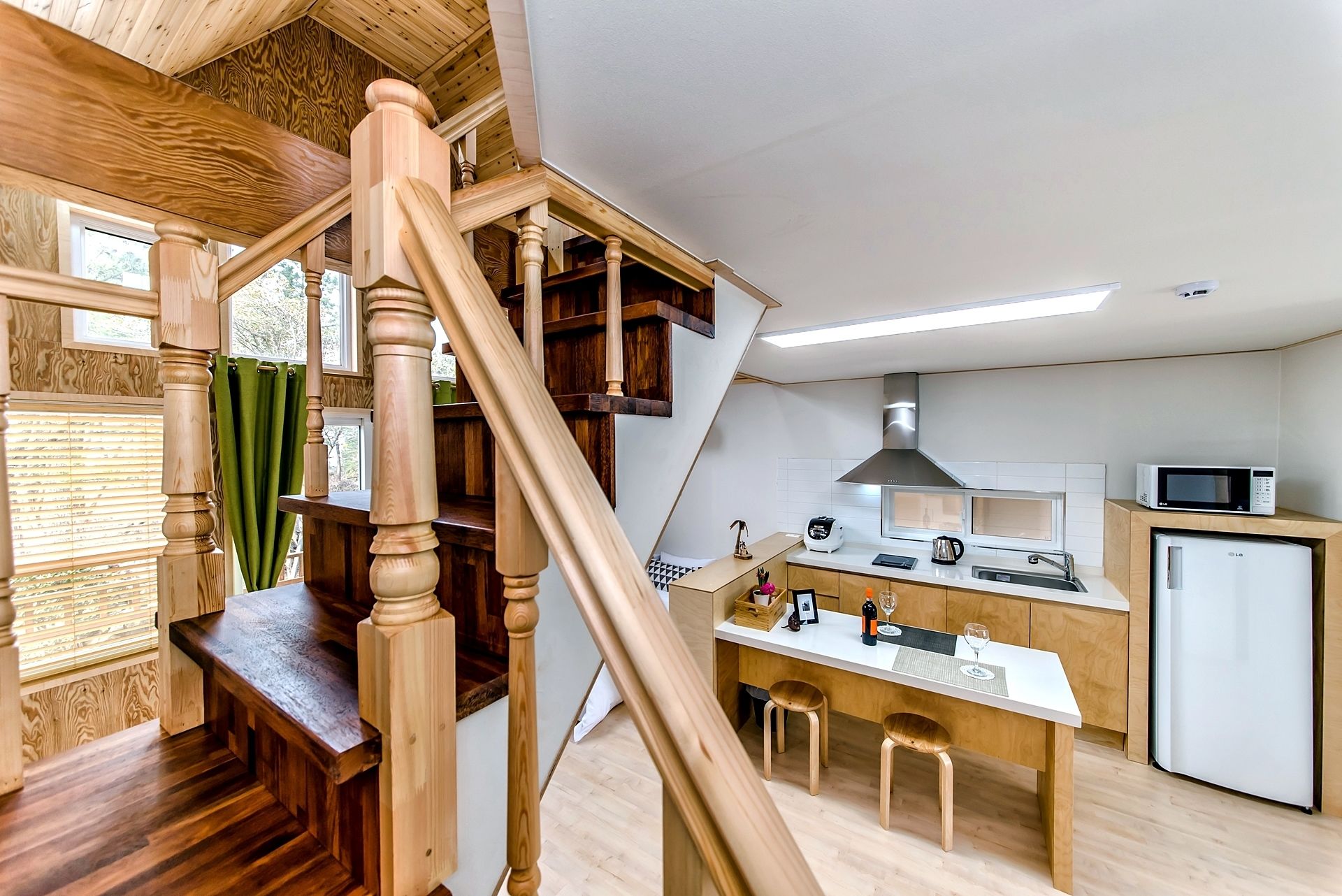 Een moderne keuken met houten details, een eetgedeelte en een trap.