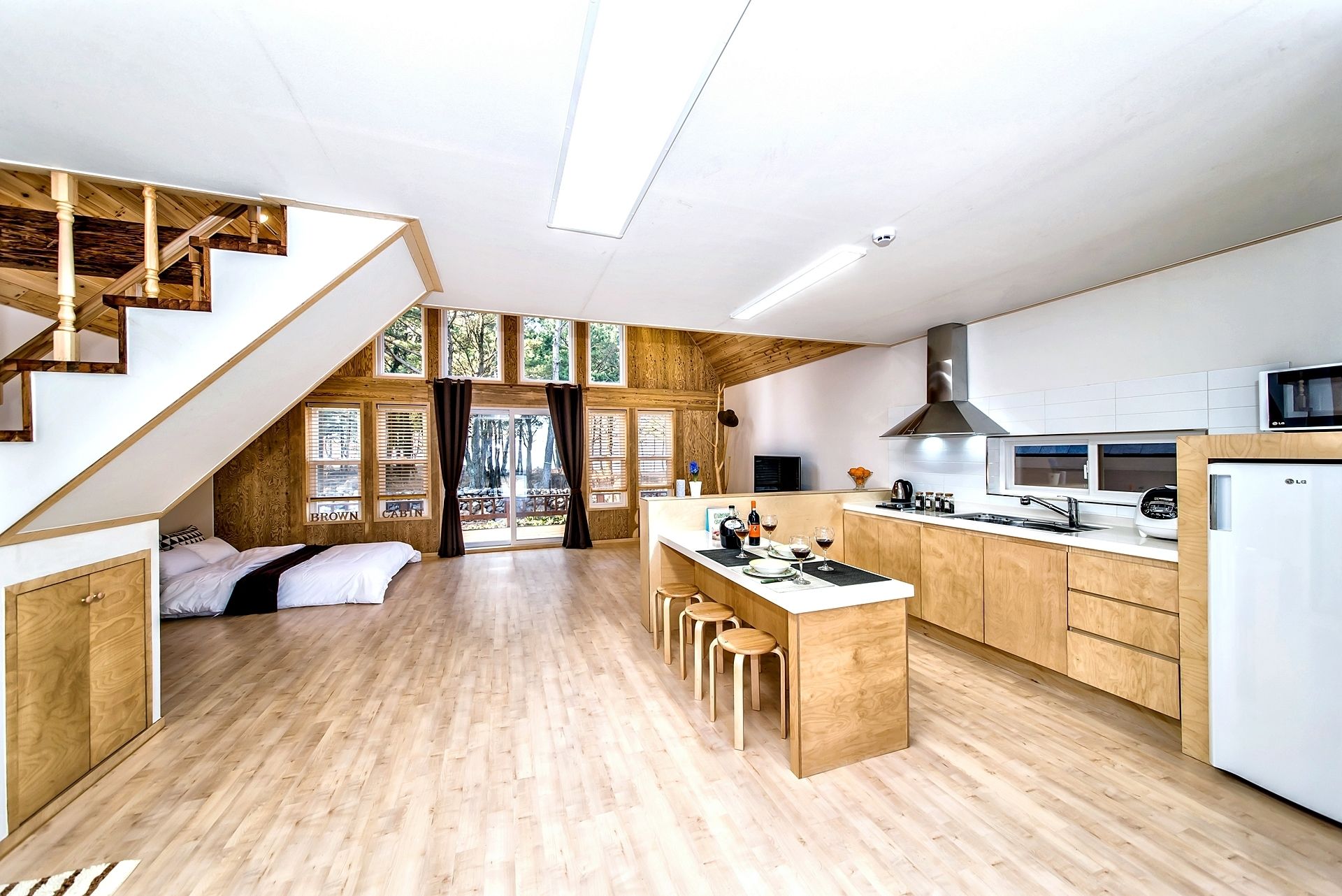 A modern kitchen with wooden cabinets, a central island, and a built-in stove.