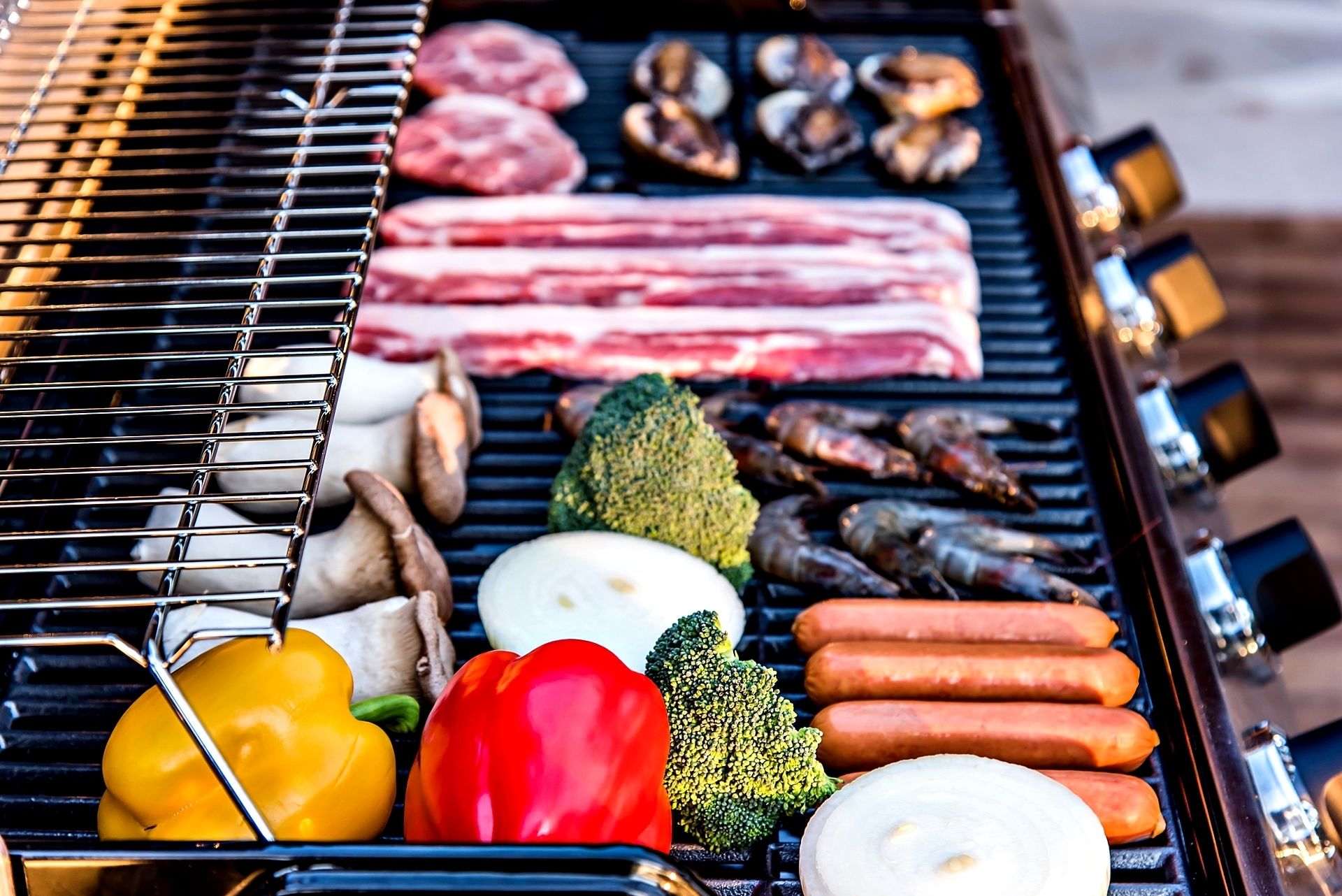 Una parrilla con carnes, verduras y mariscos.