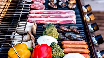 Una parrilla con carnes, verduras y mariscos.