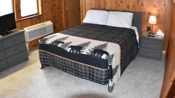 Un dormitorio con cama, cómoda, televisor y calentador.