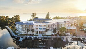 Un hôtel situé au bord de l’eau, composé de plusieurs bâtiments, de quais et abritant des bateaux.