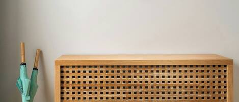 A wooden console table with a lattice top, a woven basket, and a wall-mounted fish decoration.