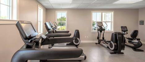 A gym with treadmills, elliptical machines, and stationary bikes.