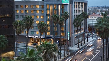 Ein modernes Hotel mit Marriott-Logo, Palmen und Blick auf die Stadtlandschaft.