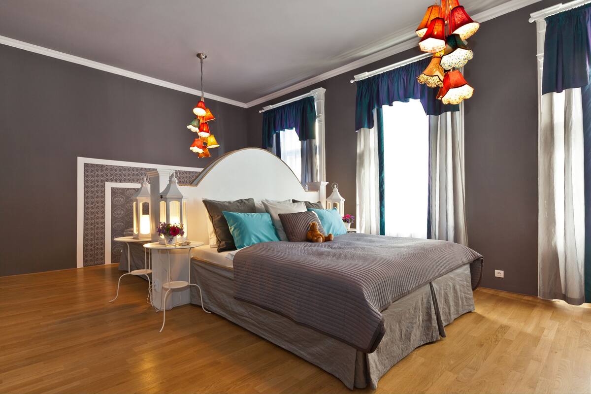 Een moderne slaapkamer met een groot bed, een nachtkastje en een bedtafel.