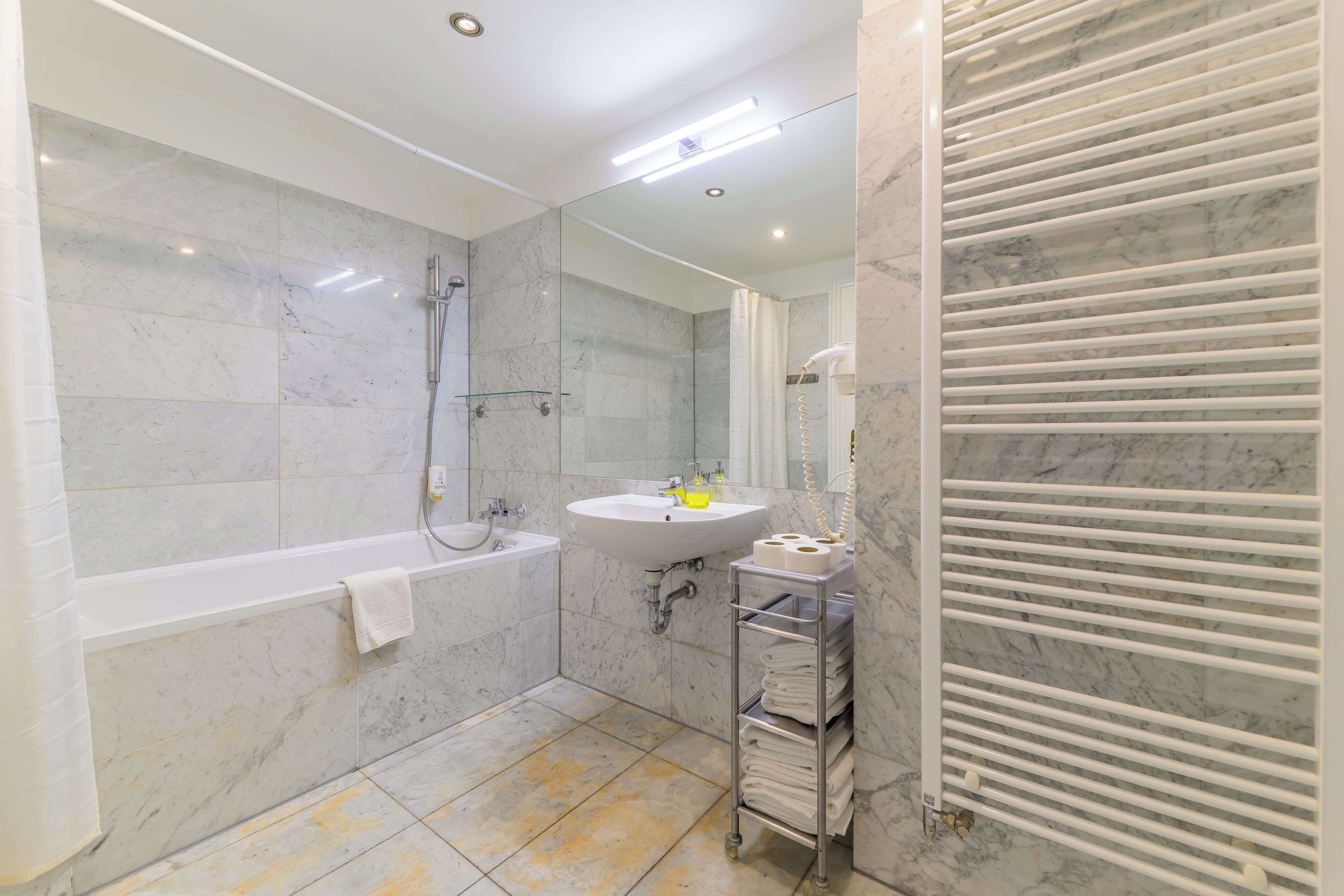 Un baño moderno con bañera, lavamanos y cabina de ducha de vidrio.