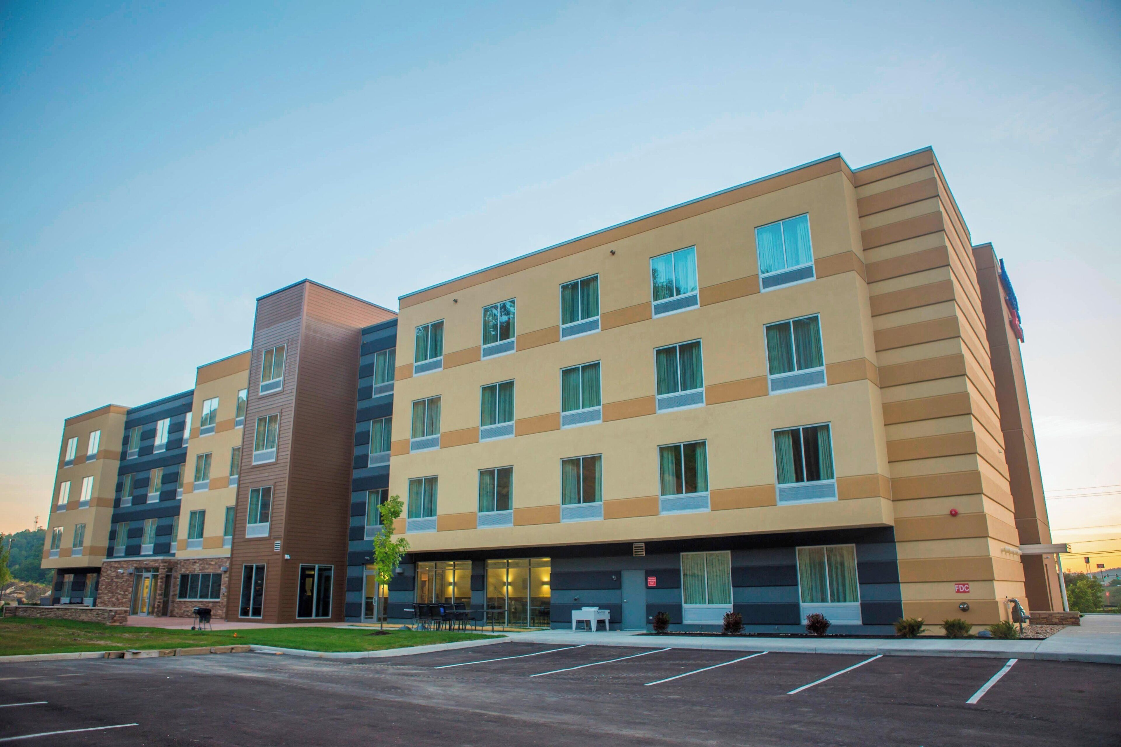 Un hôtel à plusieurs étages doté d’une architecture moderne, caractérisé par un mélange de styles de fenêtres et un toit plat.