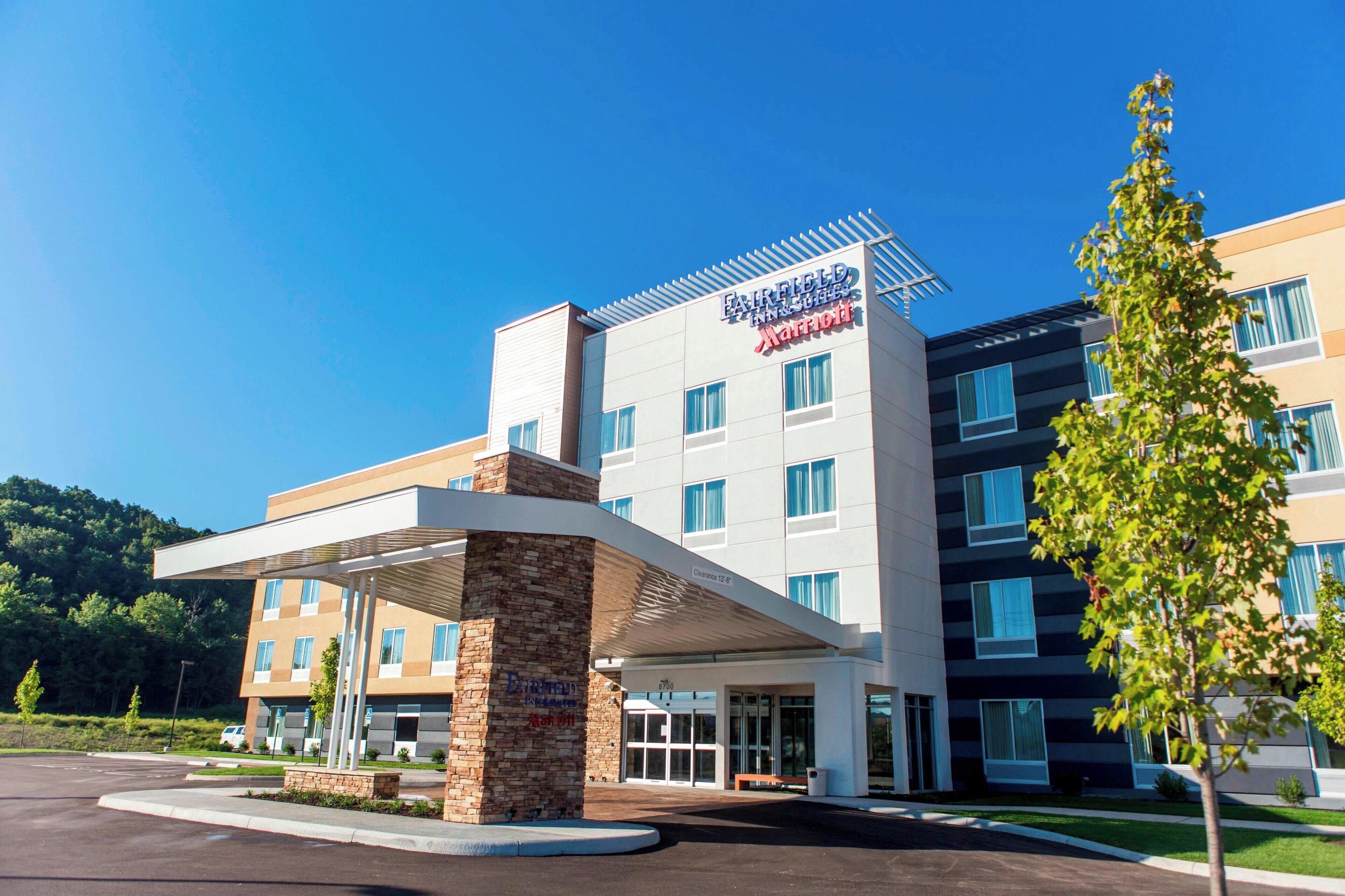 A Fairfield Inn & Suites hotel with a modern design, featuring a covered entrance and multiple floors.