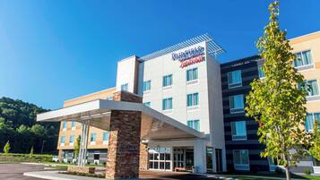 A Fairfield Inn & Suites hotel with a modern design, featuring a covered entrance and multiple floors.
