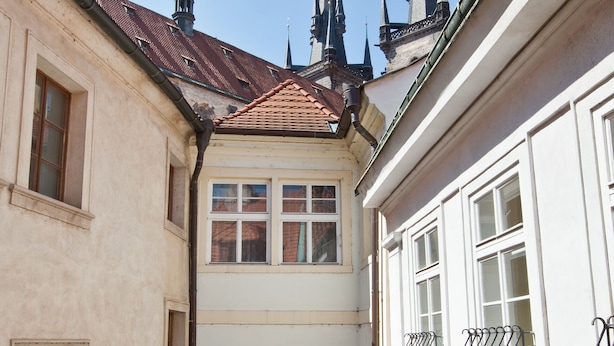 A narrow alleyway between buildings with a tiled roof and a small archway. - Cathedral Prague Apartments (Prague)
