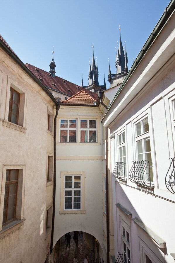 Uma ruela estreita entre edifícios, com telhado de azulejos e uma pequena passagem em arco.