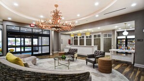 A spacious lobby with a curved seating area, a modern chandelier, and a reception desk with a counter. - Homewood Suites by Hilton Dallas Arlington South (Arlington)
