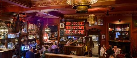 A bar with wooden decor, a chandelier, and a wine rack.