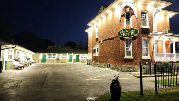 A large, well-lit brick building with a sign reading "Maple Leaf Motel."