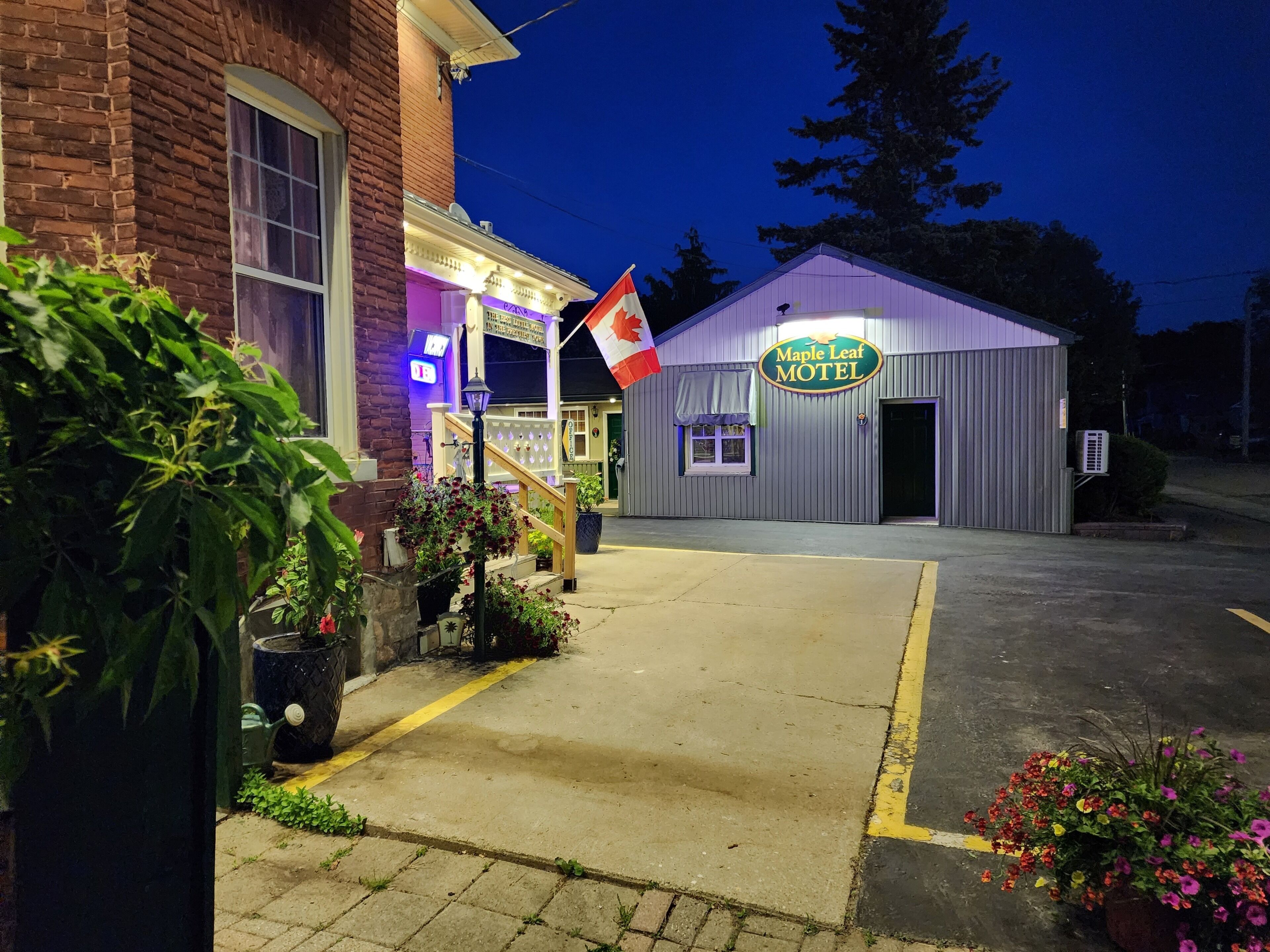 Un motel con un letrero que dice "Maple Leaf Motel" y una bandera canadiense.