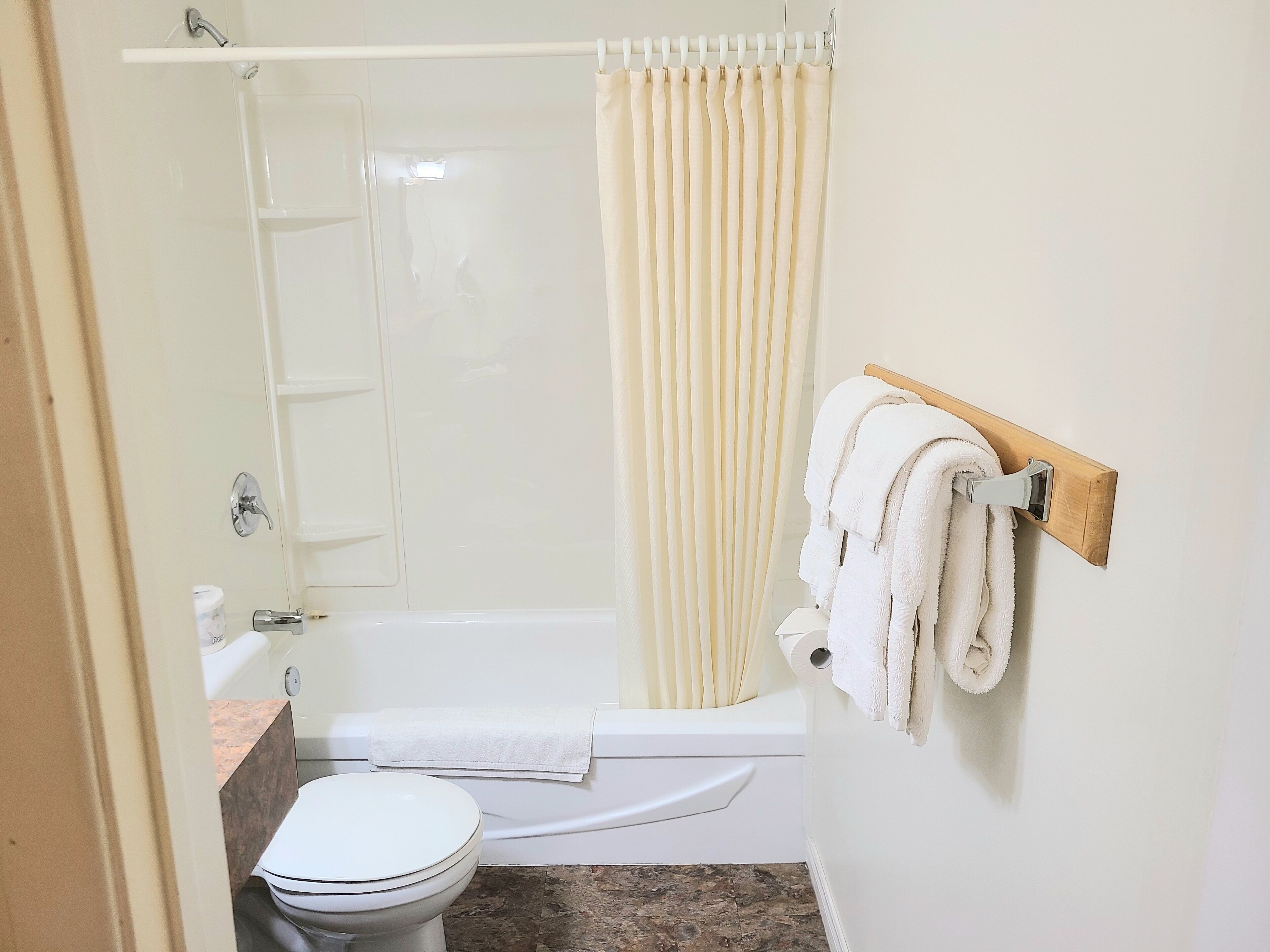 A bathroom with a bathtub, toilet, and a shower curtain.