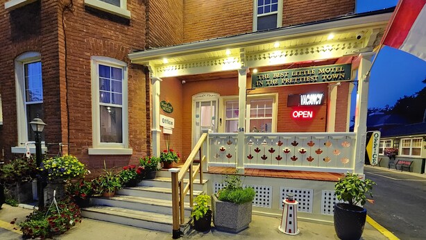 A brick building with a sign reading "The Best Little Motel in the Prettiest Town" and "Office" sign. - Maple Leaf Motel (Goderich)