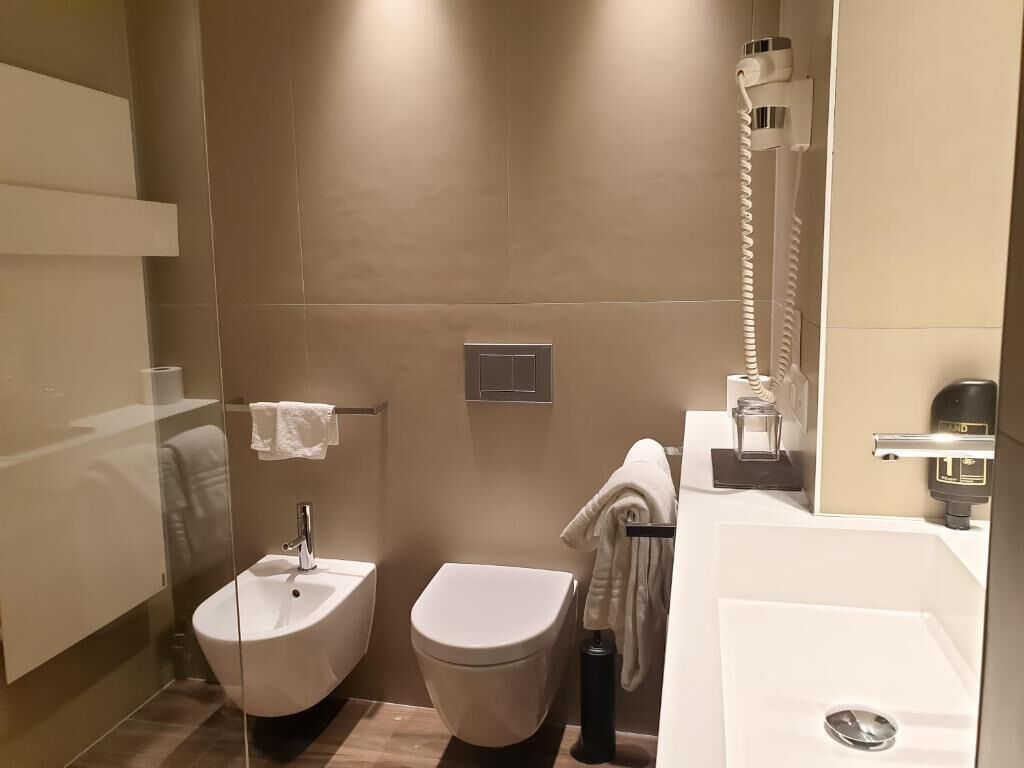 A modern bathroom with a bidet, toilet, and a large sink.