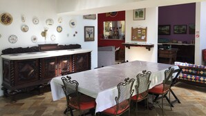 A dining area with a long table, chairs, and a wooden cabinet. - Banana Leaf Eco Hostel (Rio de Janeiro)