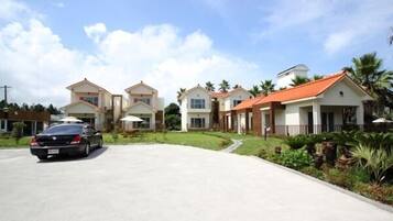 A residential area with modern houses, a paved driveway, and a car parked on the street.