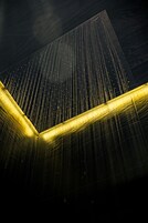 A modern architectural structure with a geometric design and illuminated elements.