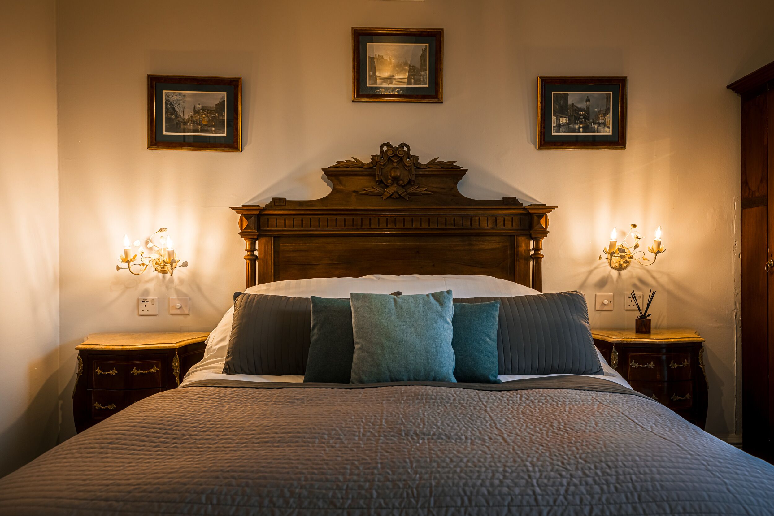 A neatly made bed with a wooden headboard, flanked by two bedside tables with lamps.