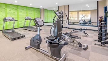 A gym with treadmills, an elliptical, and weight machines.
