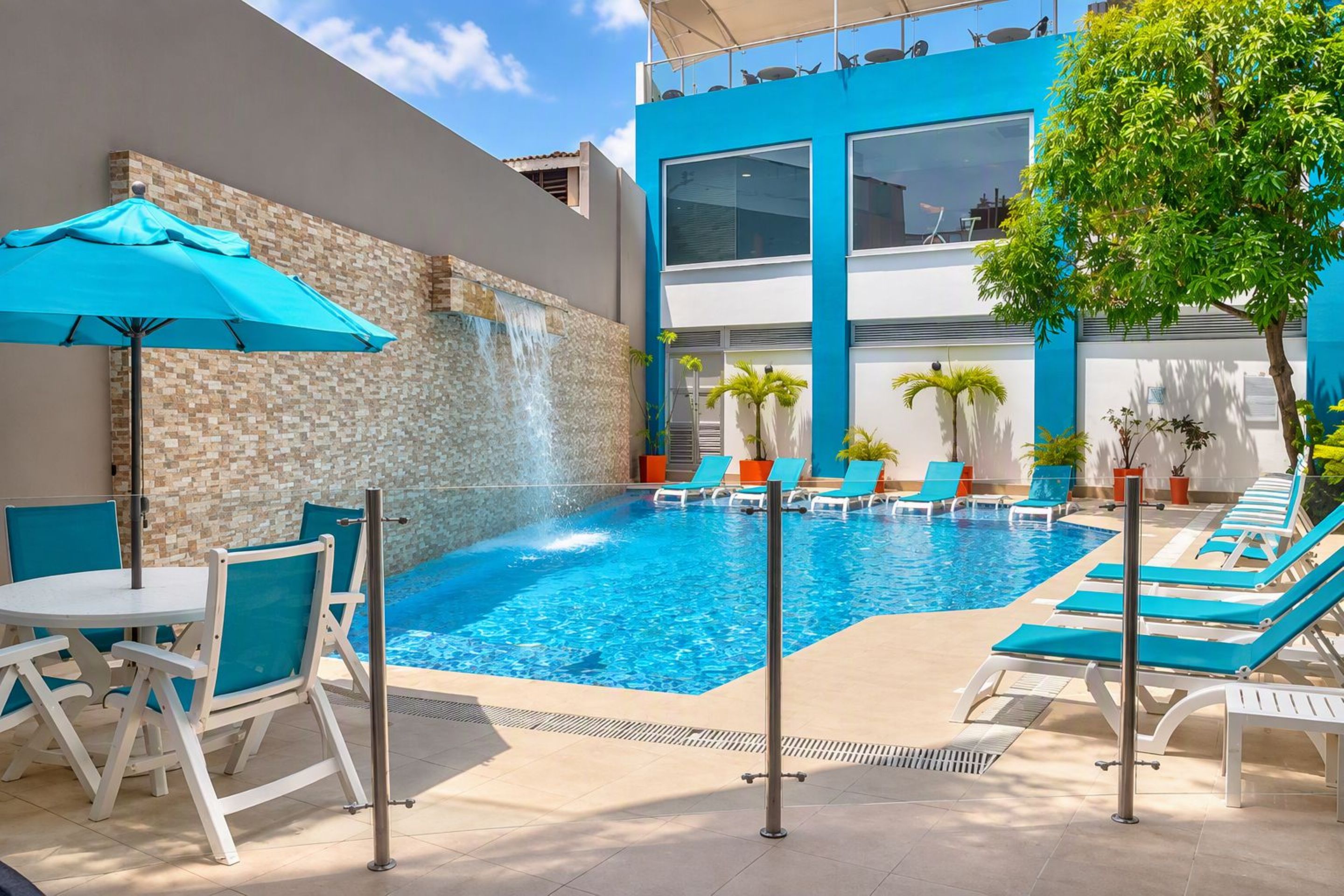 A swimming pool with lounge chairs and a waterfall feature.