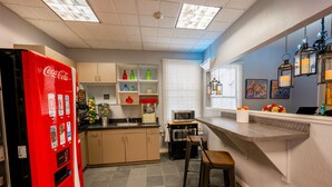 A kitchen with a red refrigerator, a microwave, and a bar area with stools. - The Urban San Francisco (San Francisco)