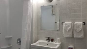 Un baño con bañera, lavamanos, inodoro y cortina de ducha.