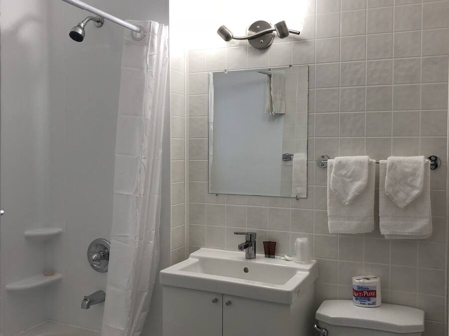 Un baño con bañera, lavamanos, inodoro y cortina de ducha.