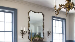 A dining room with a fireplace, wooden chairs, a table, and a chandelier. - The Little Inn of Bayfield (Bluewater)