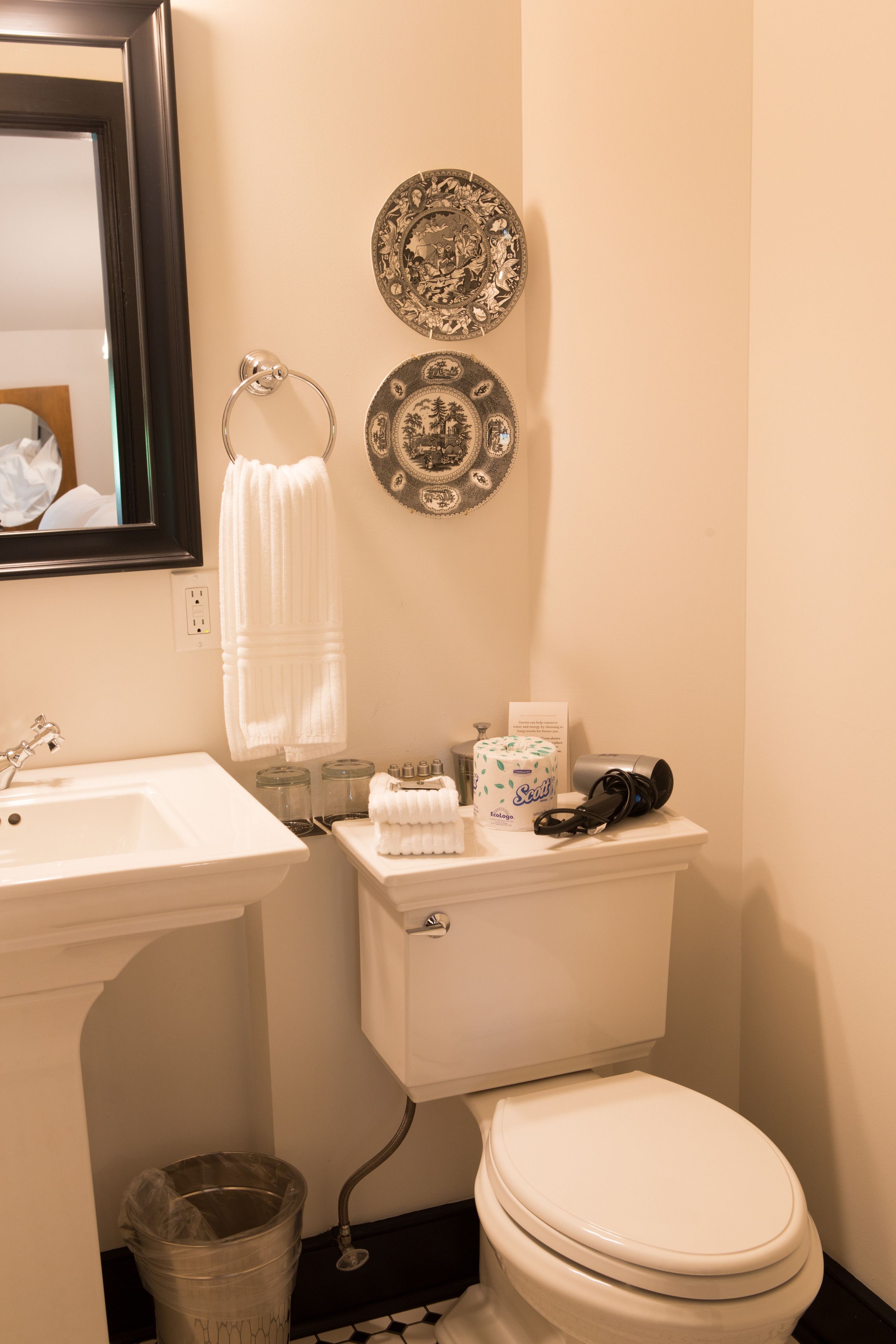 Une salle de bain avec un lavabo blanc, des toilettes et un porte-serviettes.