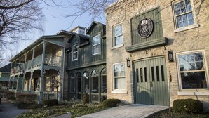 A two-story building with a green door and a sign that reads "The Little Inn." - The Little Inn of Bayfield (Bluewater)