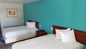 Ein Hotelzimmer mit zwei Betten, einem Nachttisch und einem Bild an der Wand.