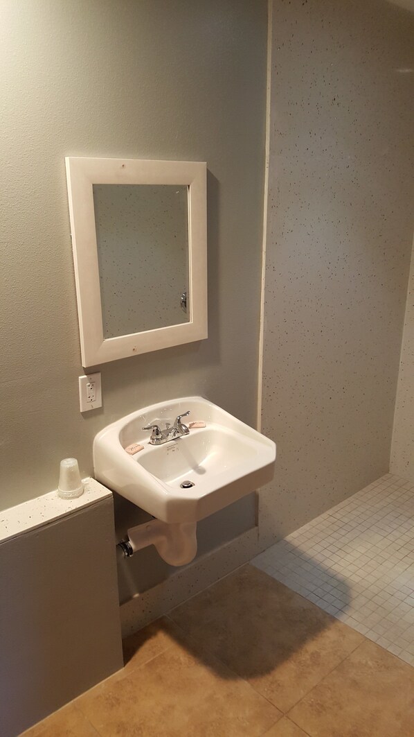 Un baño con lavamanos blanco, un espejo y un inodoro.