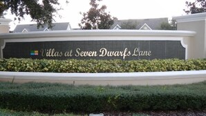 A sign for 'Villas at Seven Dwarfs Lane' with a landscaped area in front. - Villas at Seven Dwarf by FunQuest (Kissimmee)