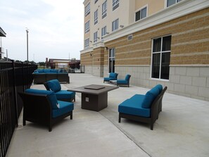 An outdoor patio area with seating arrangements and a building in the background. - Holiday Inn Jonesboro by IHG (Jonesboro)