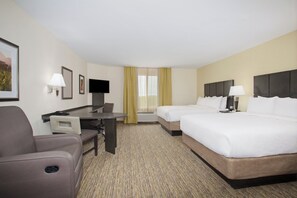 A hotel room with a desk, two beds, a chair, and a television. - Candlewood Suites Longmont - Boulder Area by IHG (Longmont)