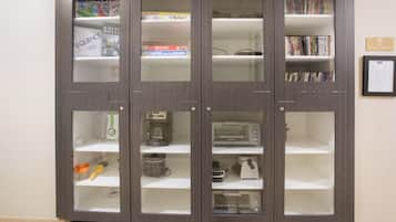 A multi-shelf cabinet with various items including books, a coffee maker, and kitchen appliances.