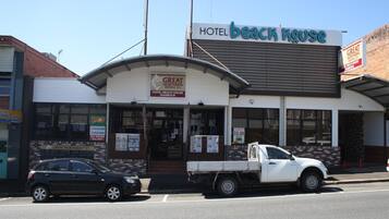 Un hotel llamado 'Hotel Beach House' con un letrero de 'Great Northern Brewing Co.' y un precio de $9.99.